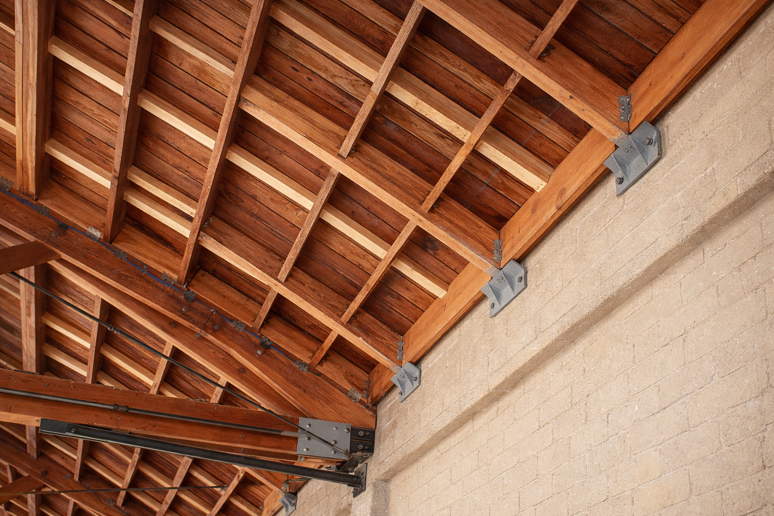 Seismic connections along timber roof framing and a masonry wall